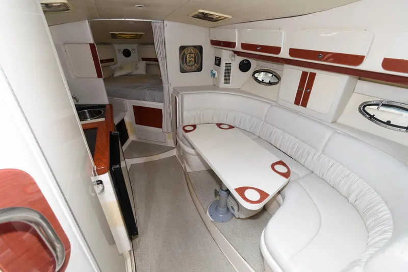 Slide: The Image of 1997 Donzi 3250 LXC cabin interior with white seating and compact kitchen area. - 12
