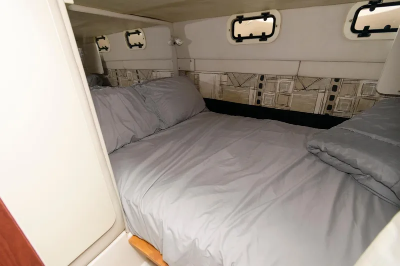 Slide: The Image of Interior cabin of a 1997 Donzi 3250 LXC boat with a cozy bed setup. - 16