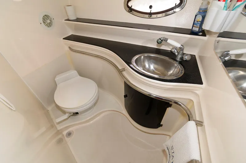 Slide: The Image of 1997 Donzi 3250 LXC boat bathroom with sink, toilet, and storage. - 18