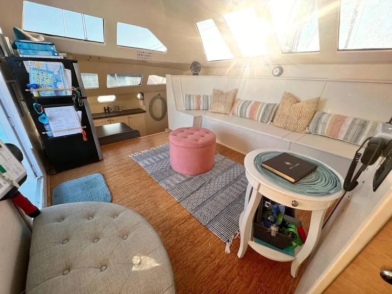 Slide: The Image of Cozy interior of 2007 Farrier F-41 catamaran with seating, ottoman, and sunlight. - 15