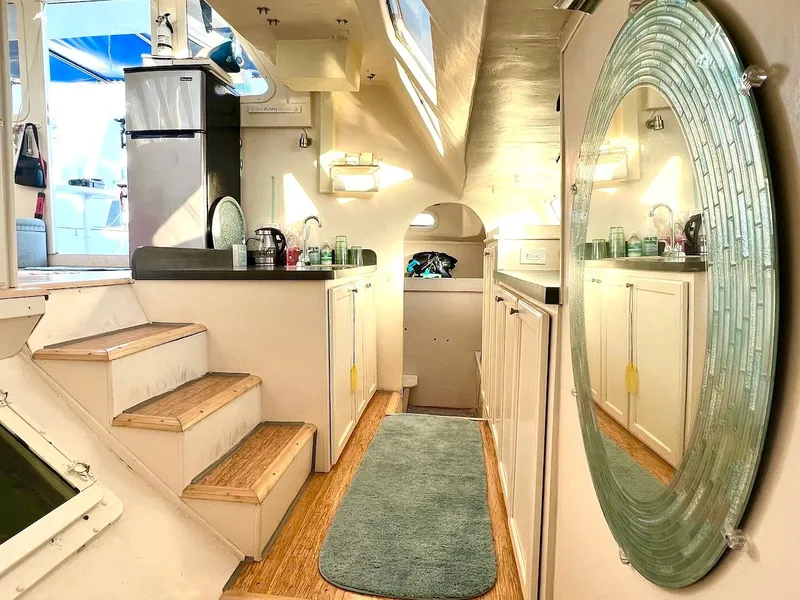 Slide: The Image of Interior of 2007 Farrier F-41 catamaran with kitchenette, stairs, and large mirror. - 17