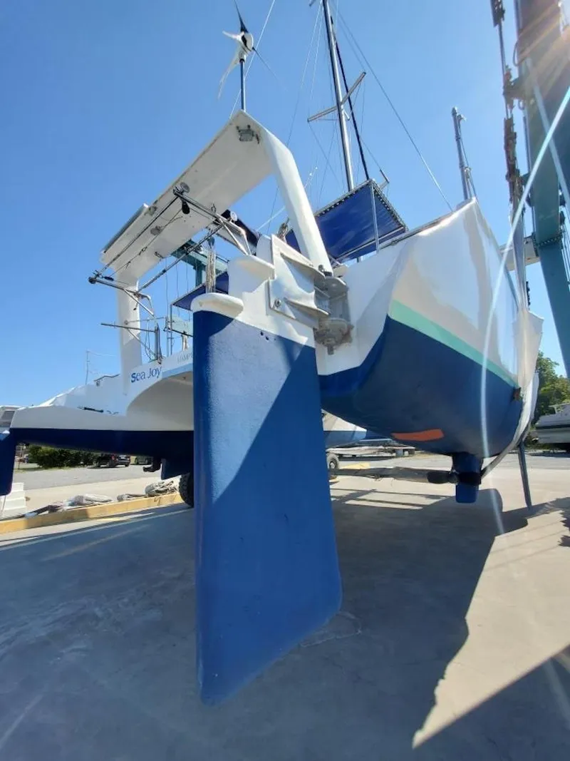 Slide: The Image of Farrier F-41 2007 catamaran on dry dock with blue rudder and white hull. - 2
