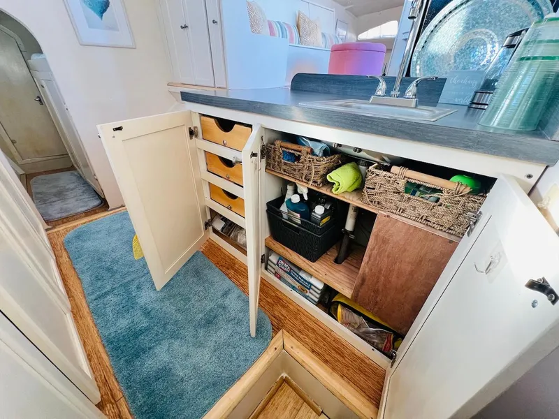 Slide: The Image of Compact kitchen storage in a 2007 Farrier F-41 sailboat with open cabinets and organized shelves. - 28
