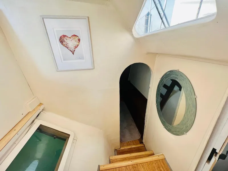 Slide: The Image of Interior of 2007 Farrier F-41 boat with stairs, porthole, and heart artwork. - 31