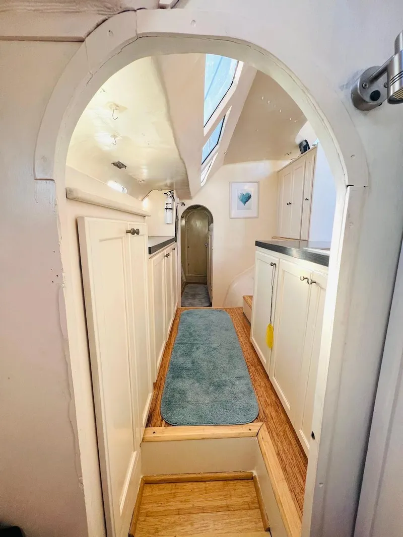 Slide: The Image of Narrow hallway inside 2007 Farrier F-41 boat with white cabinets and blue carpet. - 41