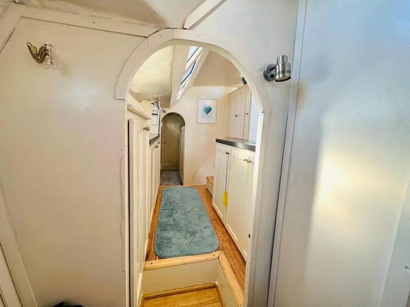 Slide: The Image of 2007 Farrier F-41 interior hallway with white walls and blue rug. - 42