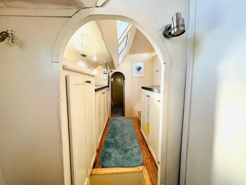Slide: The Image of Narrow hallway inside 2007 Farrier F-41 boat with white cabinets and blue carpet. - 43