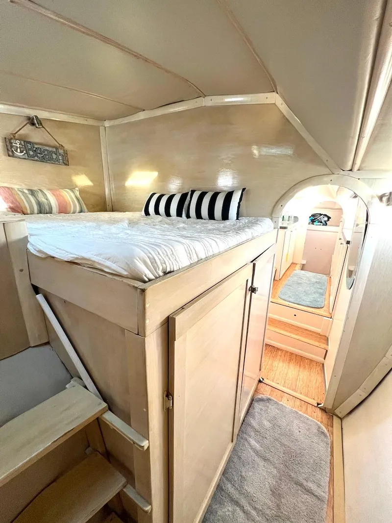 Slide: The Image of Cozy interior of a 2007 Farrier F-41 sailboat with a loft bed and wooden cabinetry. - 49