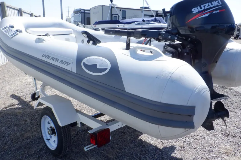 Slide: The Image of 2015 Walker Bay 325 STX Odyssey inflatable boat with Suzuki outboard motor on trailer. - 15