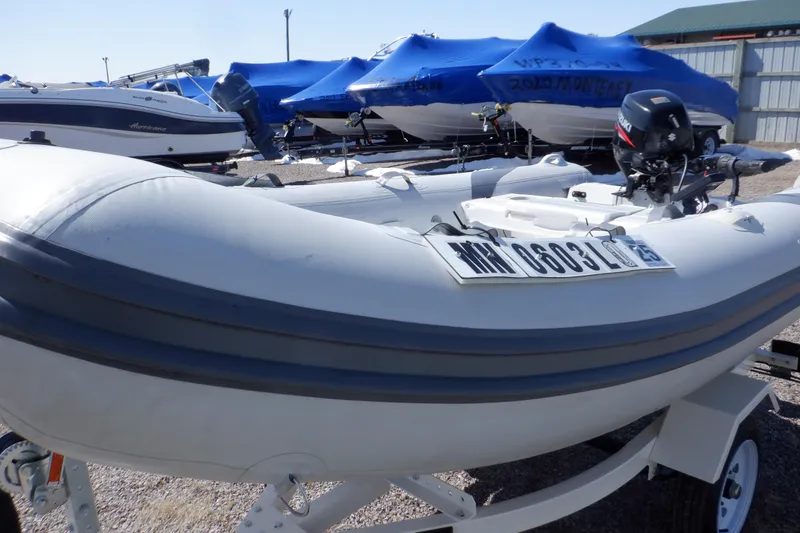 Slide: The Image of 2015 Walker Bay 325 STX Odyssey inflatable boat on trailer, with motor, in storage area. - 18