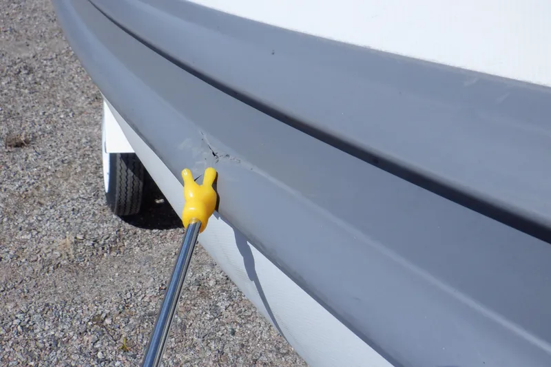 Slide: The Image of Close-up of a 2015 Walker Bay 325 STX Odyssey boat hull with a small damage mark. - 23