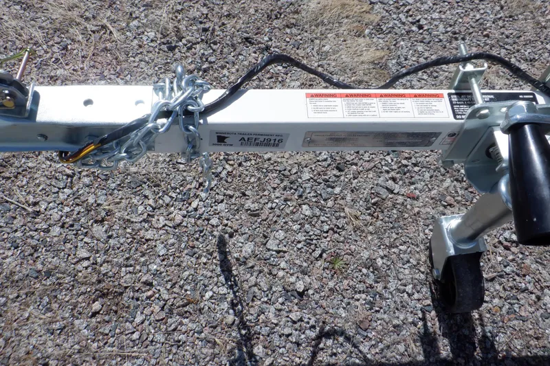 Slide: The Image of Trailer hitch of a 2015 Walker Bay 325 STX Odyssey on gravel surface. - 7