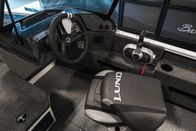 Slide: The Image of 2024 Lund 1675 Adventure Sport boat interior with steering wheel and captain's seat. - 6