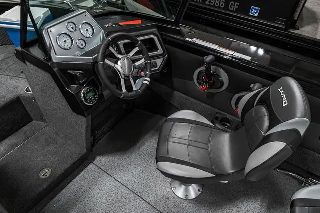 Slide: The Image of 2024 Lund 2075 Tyee Sport boat interior, featuring steering wheel and control panel. - 10