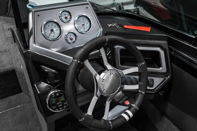 Slide: The Image of 2024 Lund 2075 Tyee Sport boat dashboard with steering wheel and gauges. - 11