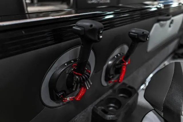 Slide: The Image of 2024 Lund 2075 Tyee Sport boat controls with safety lanyards. - 15