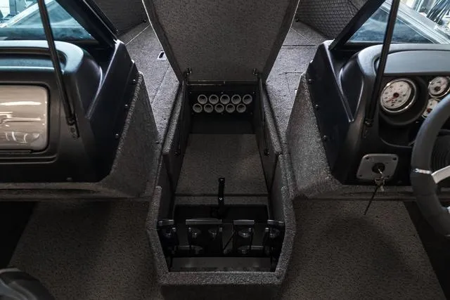 Slide: The Image of 2024 Lund 1775 Impact XS Sport boat interior with storage compartment and dashboard. - 17