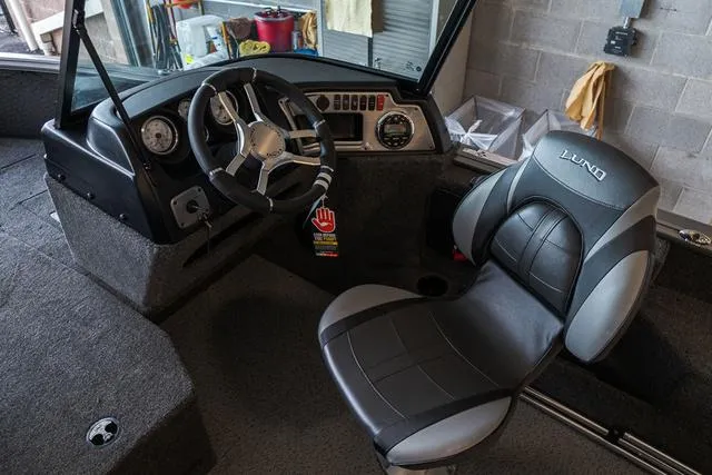 Slide: The Image of 2024 Lund 1775 Impact XS Sport boat interior with motor and storage compartments. - 8