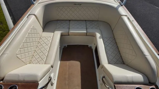 Slide: The Image of 2017 Chris-Craft 27 Launch boat interior storage compartment with beige leather seats. - 11