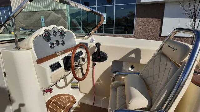 Slide: The Image of 2017 Chris-Craft 27 Launch dashboard with wooden steering wheel and instrument panel. - 17