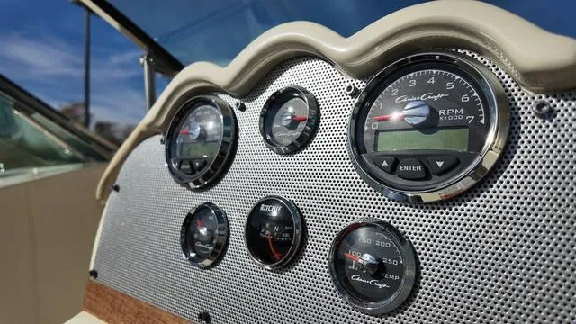 Slide: The Image of 2017 Chris-Craft 27 Launch boat interior with beige leather seats and wooden steering wheel. - 19