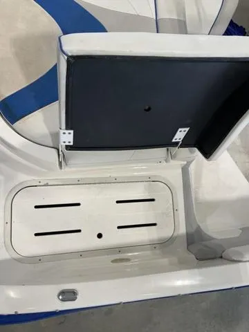 Slide: The Image of 2010 Bryant 210 BR boat interior seating area with white and blue upholstery. - 13