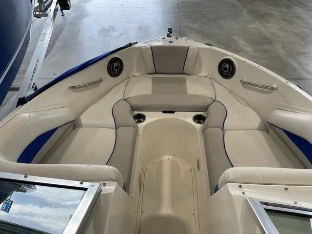 Slide: The Image of 2010 Bryant 210 BR boat interior with white seating and storage compartments. - 15