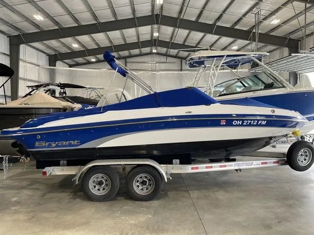 Slide: The Image of 2010 Bryant 210 BR boat with blue cover in indoor storage. - 3