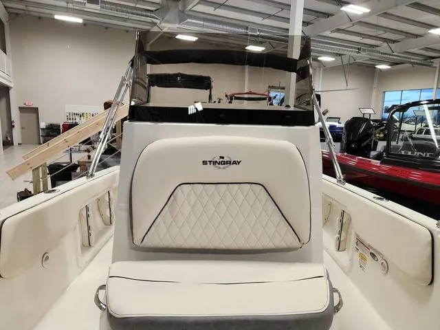Slide: The Image of 2023 Stingray 173CC boat interior with white cushioned seating in showroom. - 25