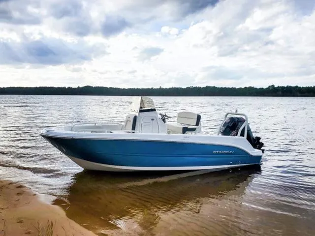 Slide: The Image of 2023 Stingray 173CC boat on a calm lake with cloudy sky. - 31