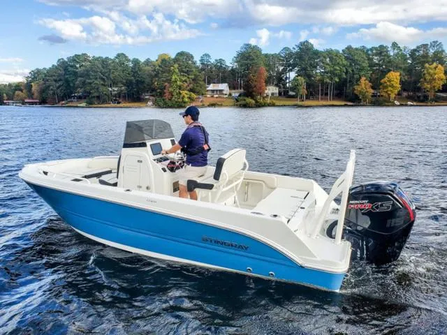 Slide: The Image of 2023 Stingray 173CC boat on a lake with a person steering. - 32