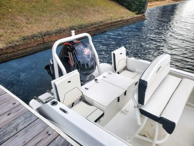 Slide: The Image of 2023 Stingray 173CC boat docked by the water, featuring a powerful outboard motor. - 36