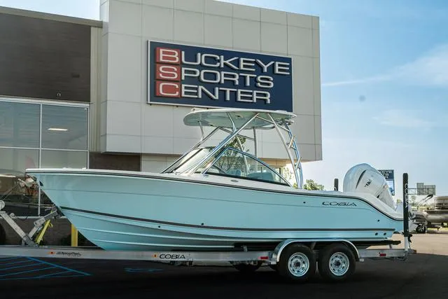 Slide: The Image of 2024 Cobia 240 DC boat on trailer in indoor storage facility. - 1