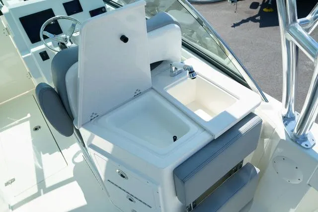 Slide: The Image of 2024 Cobia 240 DC boat interior with sink and seating area. - 10