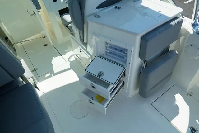 Slide: The Image of 2024 Cobia 240 DC boat interior with open storage compartments and seating. - 11