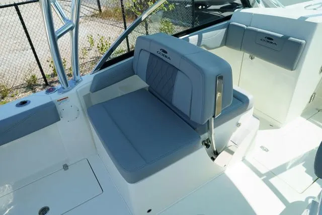 Slide: The Image of 2024 Cobia 240 DC boat interior with blue cushioned seating and sleek design. - 12