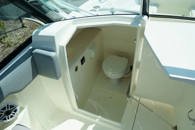 Slide: The Image of 2024 Cobia 240 DC boat interior with compact marine toilet. - 16
