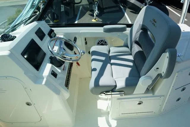 Slide: The Image of 2024 Cobia 240 DC boat cockpit with modern steering and comfortable seating. - 18