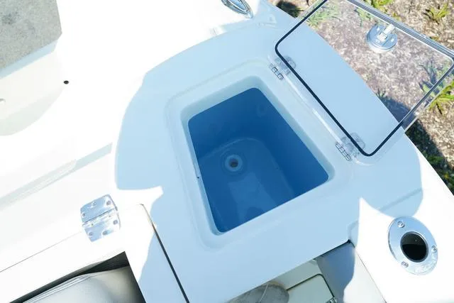 Slide: The Image of 2024 Cobia 240 DC boat livewell with open lid and rod holders. - 6