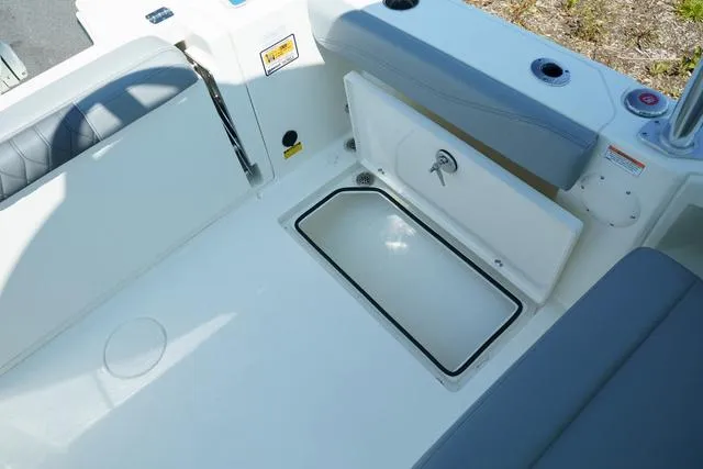 Slide: The Image of 2024 Cobia 240 DC boat interior with open storage compartment and seating. - 7