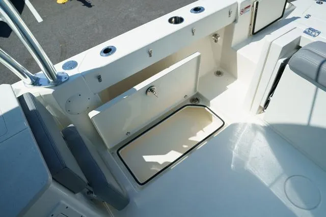 Slide: The Image of 2024 Cobia 240 DC boat interior with open storage compartment and seating. - 8