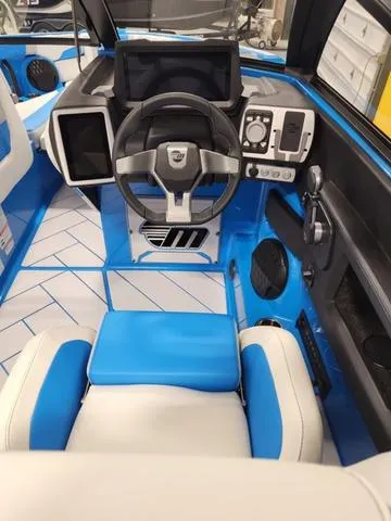 Slide: The Image of 2023 Malibu 26 LSV boat interior with modern dashboard and blue accents. - 11