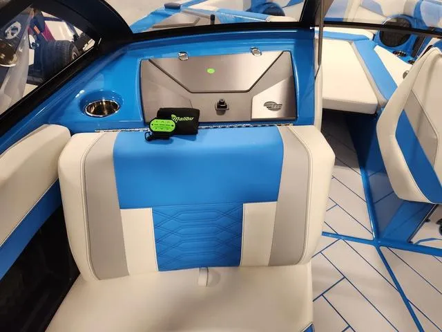 Slide: The Image of 2023 Malibu 26 LSV boat interior with blue and white seating and dashboard. - 24