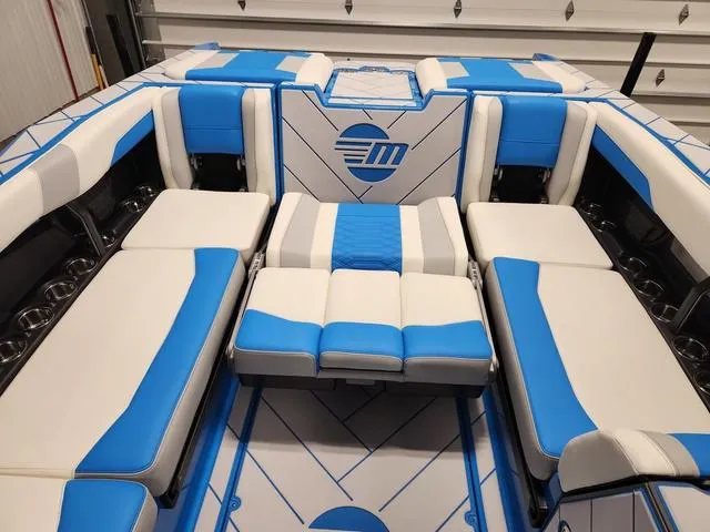 Slide: The Image of 2023 Malibu 26 LSV boat interior with blue and white seating. - 33