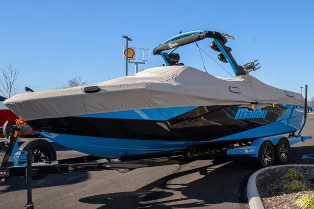Slide: The Image of 2023 Malibu 26 LSV boat with cover on trailer in parking lot. - 4