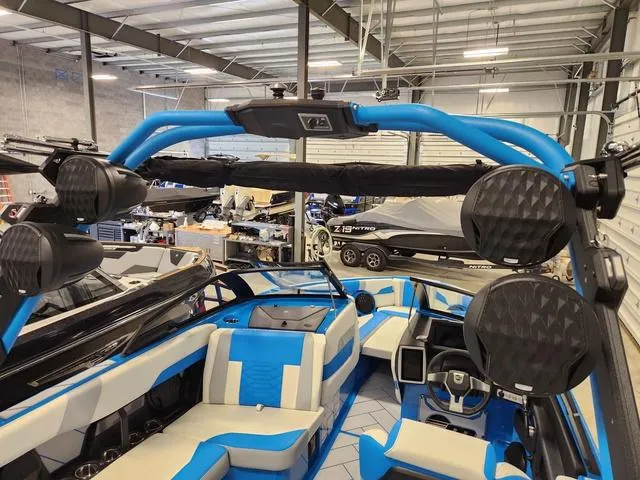 Slide: The Image of 2023 Malibu 26 LSV boat interior with blue and white seating and advanced sound system. - 43