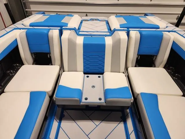 Slide: The Image of 2023 Malibu 26 LSV boat interior with blue and white seating. - 46