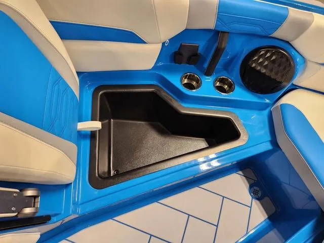 Slide: The Image of Interior of 2023 Malibu 26 LSV boat with blue and white seating, storage, and cup holders. - 48