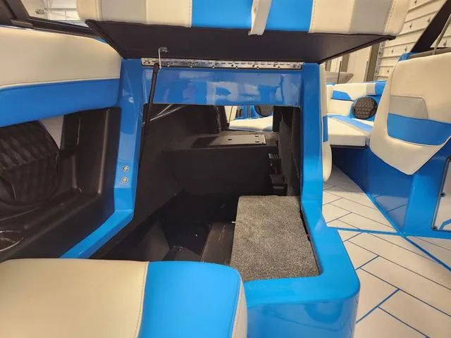Slide: The Image of 2023 Malibu 26 LSV interior storage compartment with blue and white seating. - 9