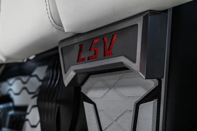 Slide: The Image of 2024 Malibu 23 LSV boat interior with white, gray, and red seating and cup holders. - 18